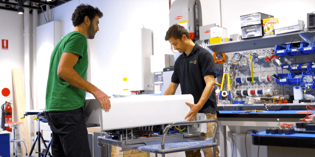 Jack Taylor and Cameron Knox in the factory where Allume SolShare is being manufactured. They both hold the SolShare unit on the photo.