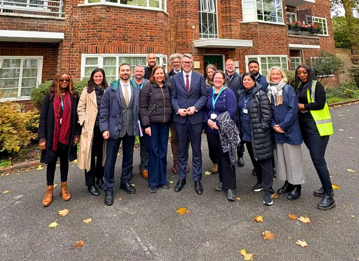 Allume UK team and partners, including Net Zero managers, outside a brick social housing block in London following a successful SolShare installation to improve EPC ratings and tenant energy resilience.